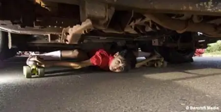 Гуттаперчивый мальчик проезжает под автомобилем.