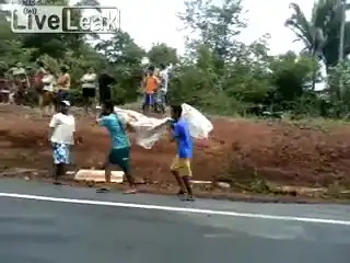 Люди крадут мясо из перевернувшегося грузовика