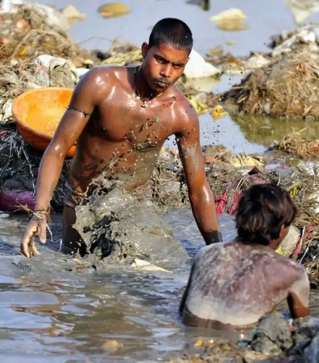 Поиск монет в мутных водах Ганга после самого большого в мире фестиваля